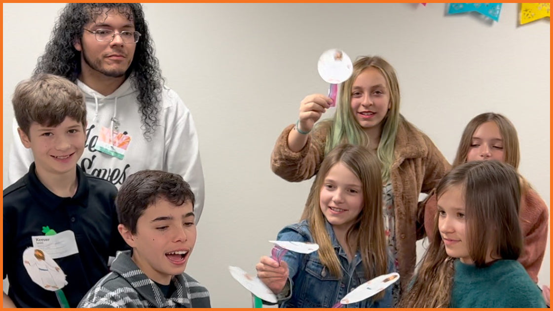 Children showing off Spyence take-home projects that encourage inviting friends